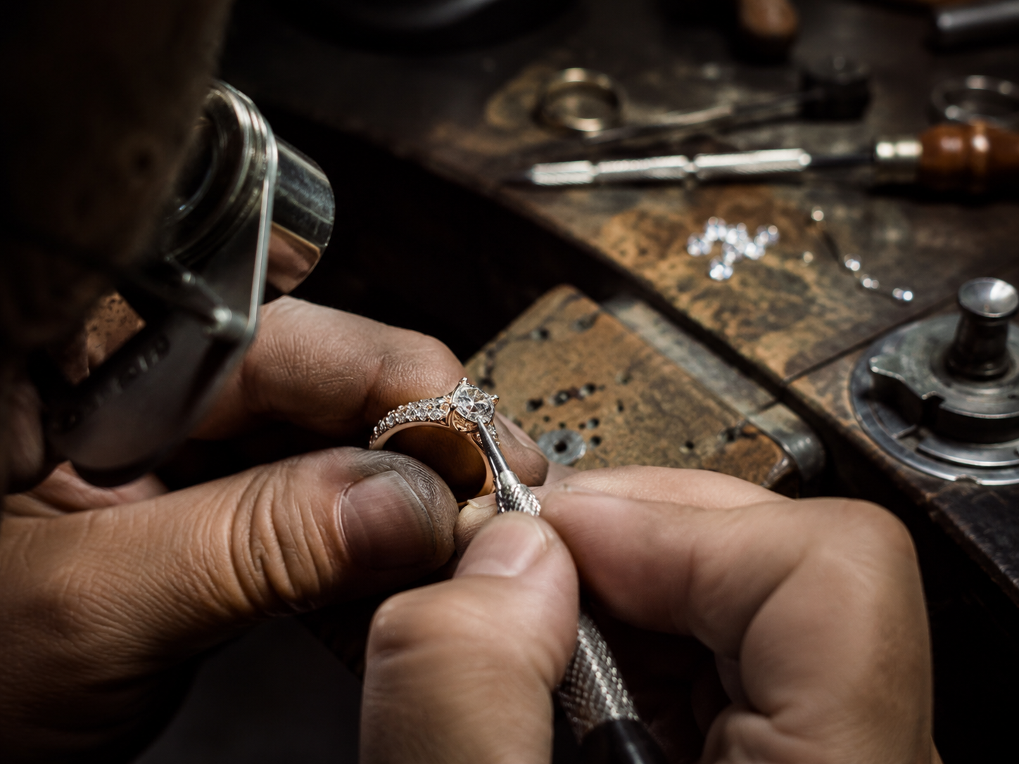 Bench jeweler setting stones and crafting a ring